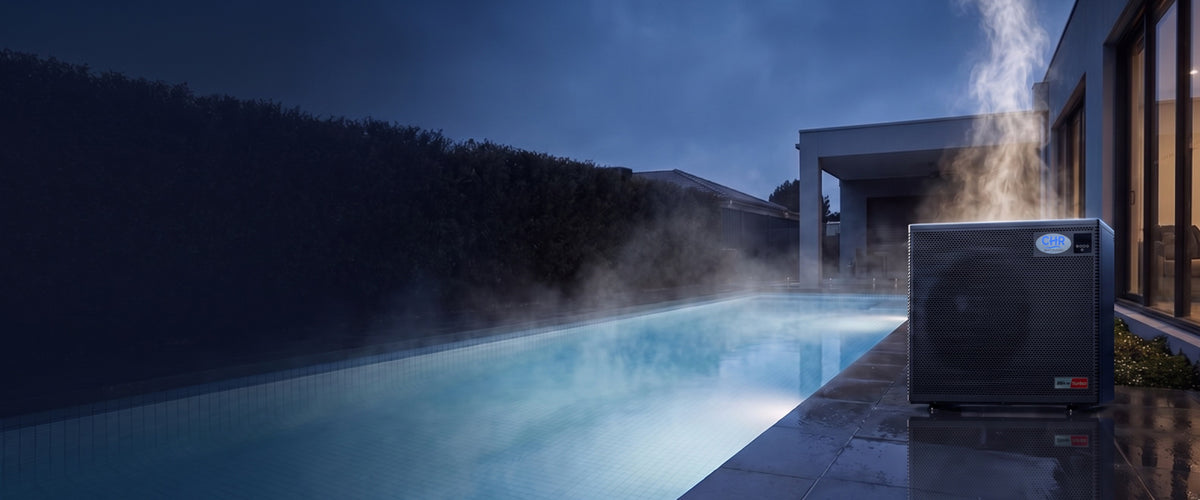 CHR 35kW single phase pool heat pump beside a steaming pool at dusk
